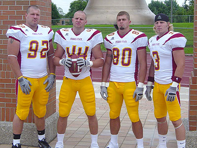 Bulldog players Kory Deering (#92), Matt Ryan (#44), Damien Miller (#80) and Mike Ryan (#3) pose for a photo in front of FSU's Victory Bell