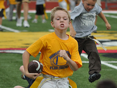 A youth football player heads for the endzone in Wednesday's flag football action at Top Taggart Field (Photo by Rob Bentley)