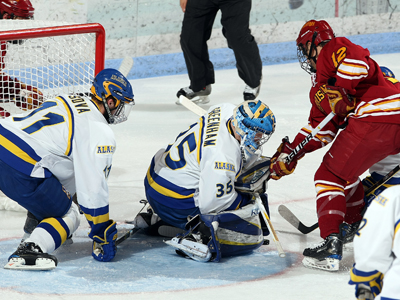 Aaron Lewicki gets his stick tied up with Alaska goaltender Scott Greenham in Friday's CCHA opener. (Photo by Paul McCarthy)