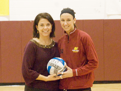 Ferris State women's volleyball head coach Tia Brandel-Wilhelm presents Kristy Gilchrist with a ceremonial ball honoring her 1,000th career kill. (Photo by Joe Gorby)