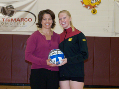 Samantha Fordyce receives a ceremonial 2,000 career assists ball from head coach Tia Brandel-Wilhelm.